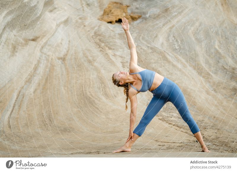 Konzentrierte Frau in Dreieckspose im Freien meditieren Yoga Triangel-Pose Konzentration Stressabbau Zen Harmonie üben Wellness Vitalität Gesunder Lebensstil