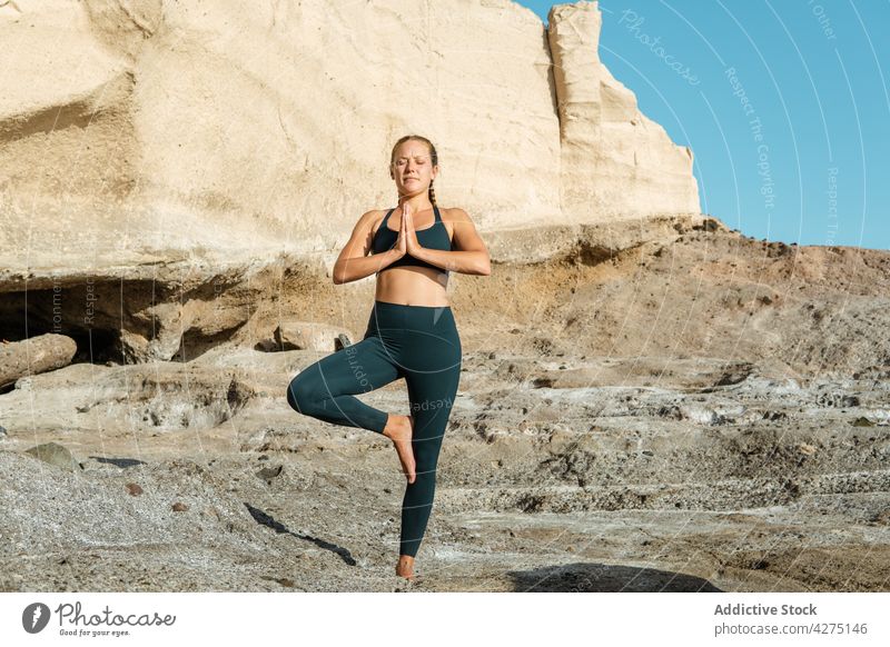 Konzentrierte Frau in Baumpose im Freien meditieren Yoga Baumhaltung Konzentration Stressabbau vrksasana Zen üben Wellness Augen geschlossen Vitalität