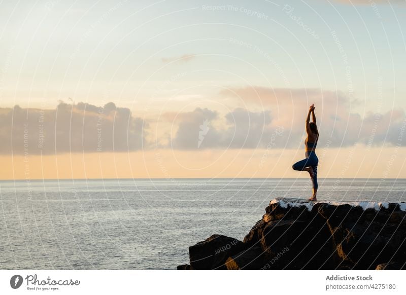 Gesichtslose Frau Durchführung Baum mit Armen nach oben Pose gegen Meer Baum mit erhobenen Armen Yoga Gleichgewicht Gesunder Lebensstil Energie Wellness MEER