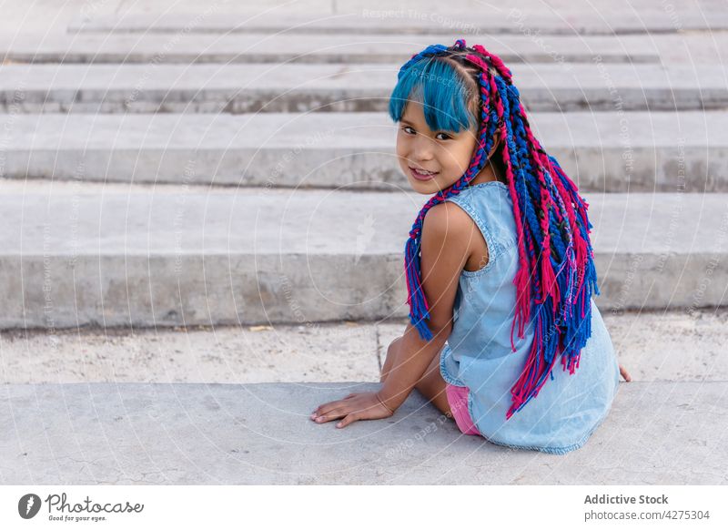 Mexikanisches Mädchen ruht sich auf einer Treppe im Freien aus verträumt Kindheit Lifestyle Geflecht charmant Treppenhaus Lächeln bewundern freundlich