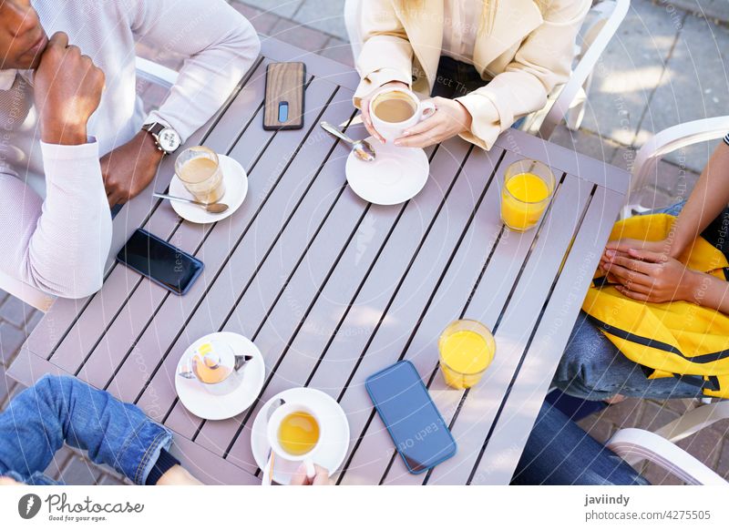 Draufsicht auf Menschen, die am Tisch auf der Terrasse einer Bar sitzen und einige Getränke trinken. Kaffee Café Tasse Freunde Tee unkenntlich Sitzung