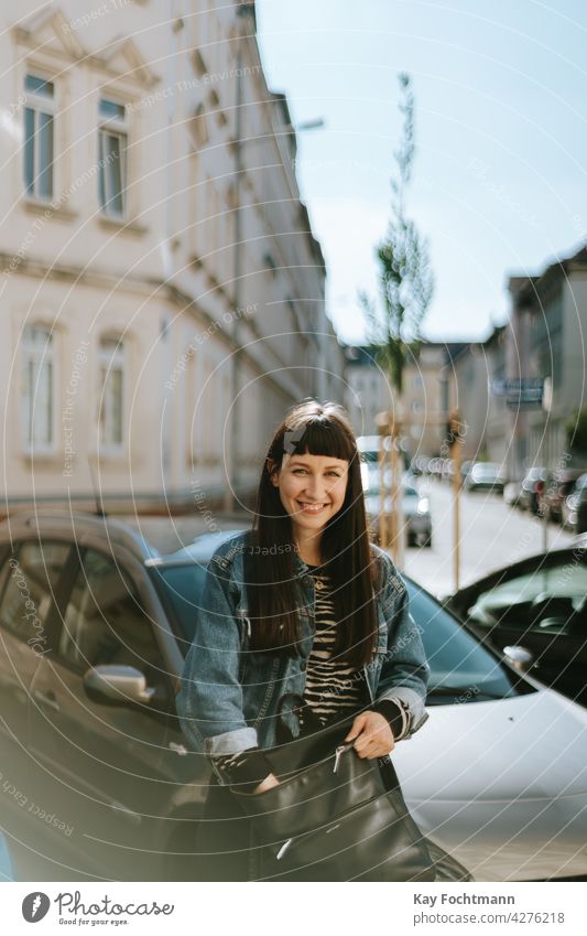 junge Frau lächelt in die Kamera Erwachsener attraktiv schön sorgenfrei Autos lässig Kaukasier heiter schick niedlich Jeansstoff elegant Brille Weiblichkeit