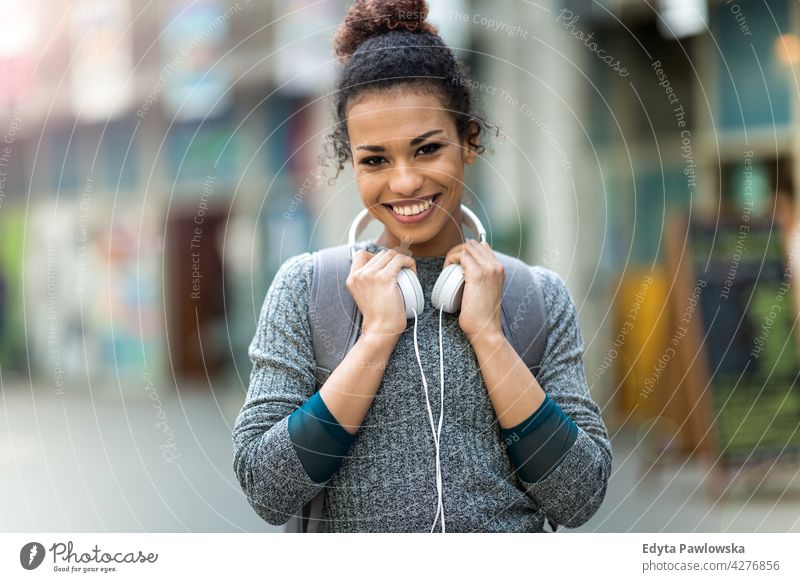 Junge Frau mit Kopfhörern im Freien Tag Positivität selbstbewusst sorgenfrei Menschen jung junger Erwachsener lässig schön attraktiv eine Person Lächeln Glück