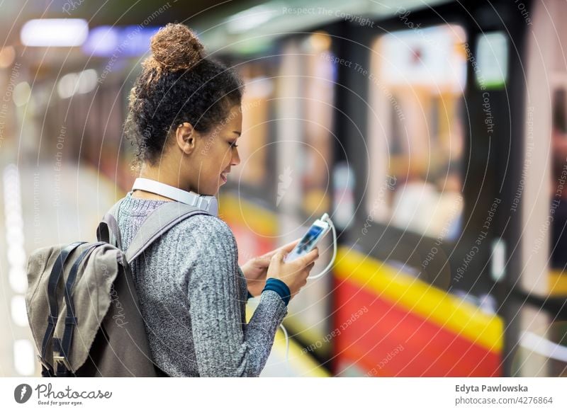 Frau benutzt Mobiltelefon in der U-Bahn-Station im Freien Tag Positivität selbstbewusst sorgenfrei Menschen jung junger Erwachsener lässig schön attraktiv