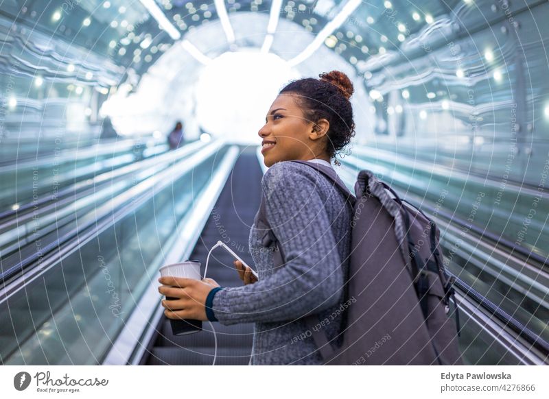 Junge Frau auf Rolltreppe mit Smartphone im Freien Tag Positivität selbstbewusst sorgenfrei Menschen jung junger Erwachsener lässig schön attraktiv eine Person