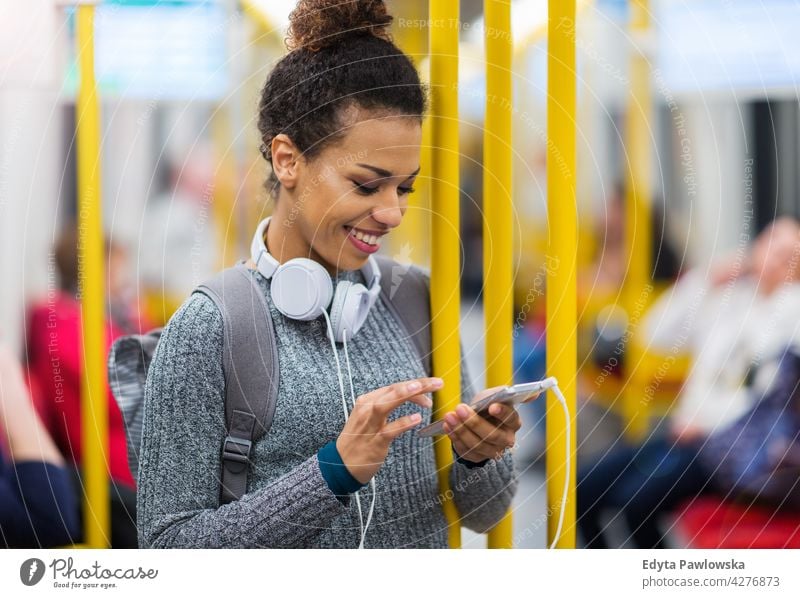 Junge Frau benutzt Mobiltelefon in der U-Bahn im Freien Tag Positivität selbstbewusst sorgenfrei Menschen jung junger Erwachsener lässig schön attraktiv