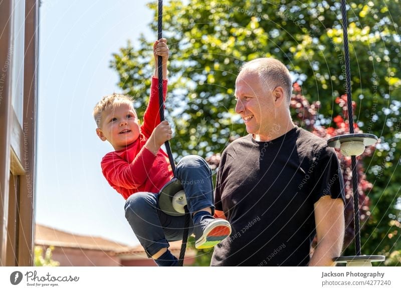 Vater spielt mit seinem 3 Jahre alten Sohn auf dem Spielplatz Spaß Kind Kleinkind Kinder Porträt Natur Lachen Bonden Zusammengehörigkeitsgefühl Elternschaft