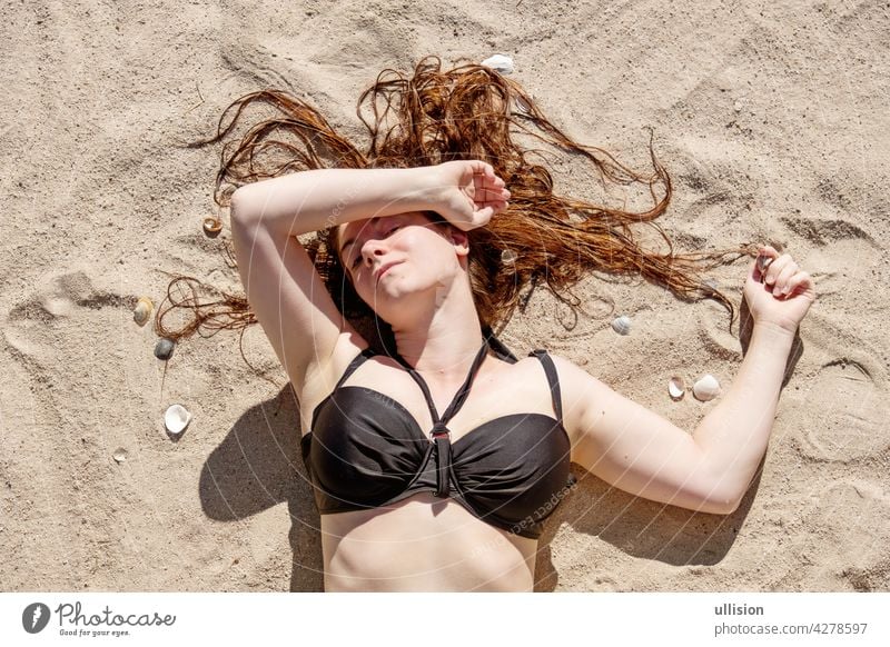 schöne junge Frau im schwarzen Bikini liegen in der Sonne am Strand in den Sand sexy Porträt Mädchen Sommer Behaarung reisen Mode Kleid Schönheit Körper Model