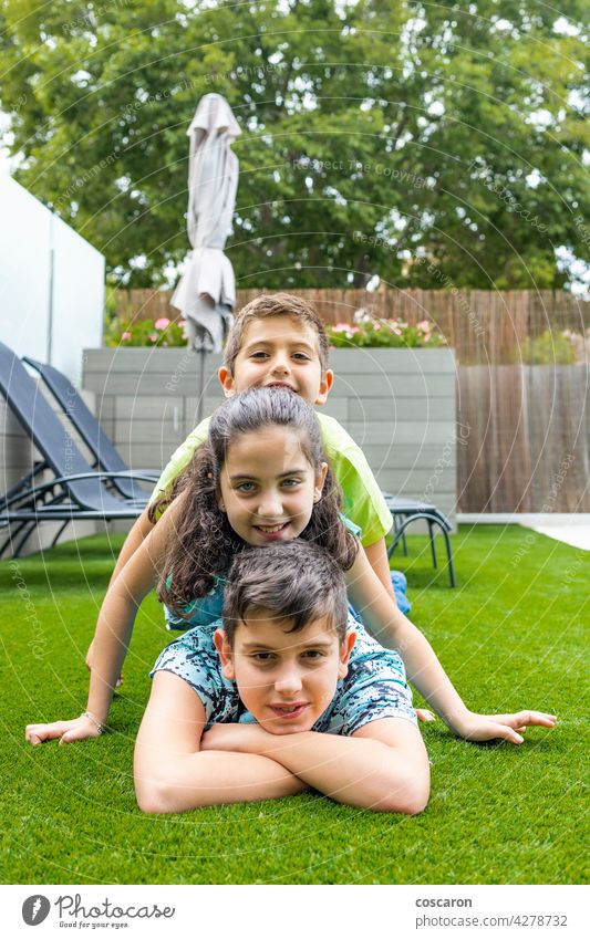 Porträt von drei Kindern auf einem Gras liegend Hintergrund schön Junge lässig Kaukasier heiter Kindheit genießen Familie Feld Freunde Freundschaft Spaß Mädchen