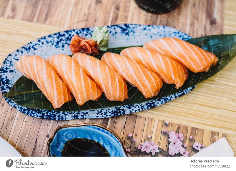 Teller mit Lachs-Niguiri mit Sojasauce in einem Sushi-Restaurant Amuse-Gueule Asien asiatisch sortiert Hintergrund Nahaufnahme Nahaufnahme japanisches Essen