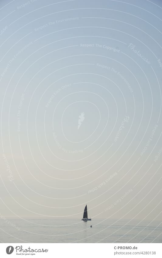 Segelyacht im Abendlicht Meer Ostsee Warnemünde Segelboot Horizont Himmel pastel fernweh segeln Boje Wasser Textfreiraum oben weite Unendlichkeit reisen