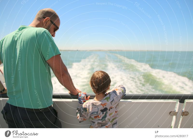 Vater und Kind schauen vom Boot aus auf das Wasser Abenteurer Kindheit Porträt glückliche Glück zufrieden Zufriedenheit Sohn Wasserfahrzeug beeindruckend