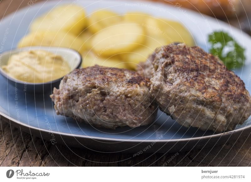 bayerische Fleischplanzerl mit Kartoffelsalat Holz Bier Essen Küche hausgemacht Teller Breze Brezel pflanzerl Rindfleisch deftig geröstet gebacken gegrillt