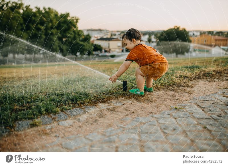 Kind spielt mit Wassersprinkler Kindheit Kaukasier 1-3 Jahre Sommer Gras Sprinkleranlage Spaß haben nass Natur Außenaufnahme Freude Spielen Tag