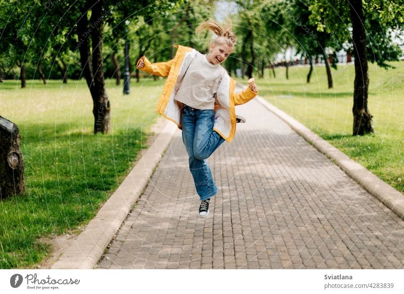 Ein Teenager-Mädchen zu Fuß im Park mit Eis in den Händen springen. Kind im Freien Sommer Rückansicht Speiseeis lustig Stilrichtung blond Spaß Glück niedlich