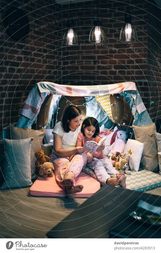 Mutter und Tochter, die eine Pyjama-Party haben und ein Buch lesen aussagekräftig diy Zelt Tipi Zusammensein gemütlich Genuss Kind Familie heimwärts Camping