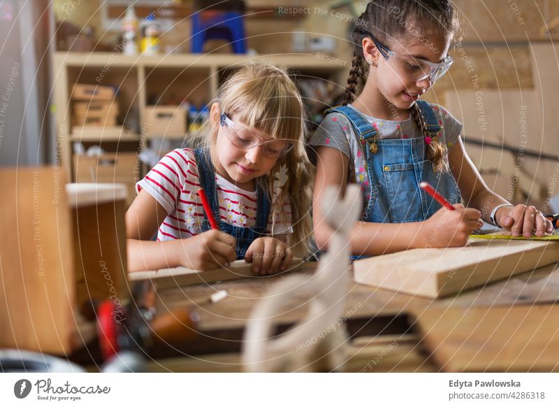 Zwei junge Mädchen bei der Holzarbeit in einer Werkstatt arbeiten Menschen Kind Kinder Frauenpower Fähigkeit Handwerk Garage Hobby Lifestyle Werkzeuge