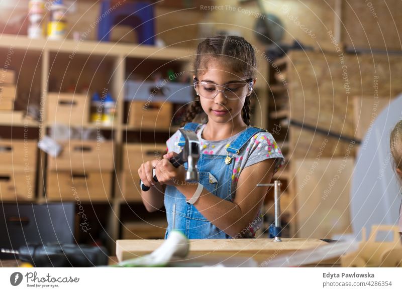 Junges Mädchen bei Holzarbeiten in einer Werkstatt Menschen Kind Kinder Frauenpower Fähigkeit Handwerk Garage Hobby Lifestyle Werkzeuge Konzentration