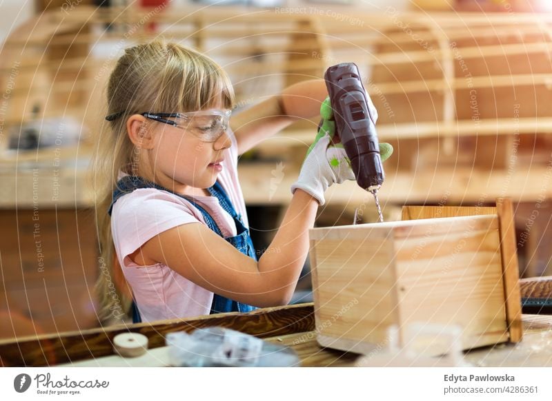 Mädchen baut Vogelhaus in Garage Werkstatt arbeiten Menschen Kind Kinder Frauenpower Fähigkeit Handwerk Hobby Lifestyle Werkzeuge Konzentration Kreativität