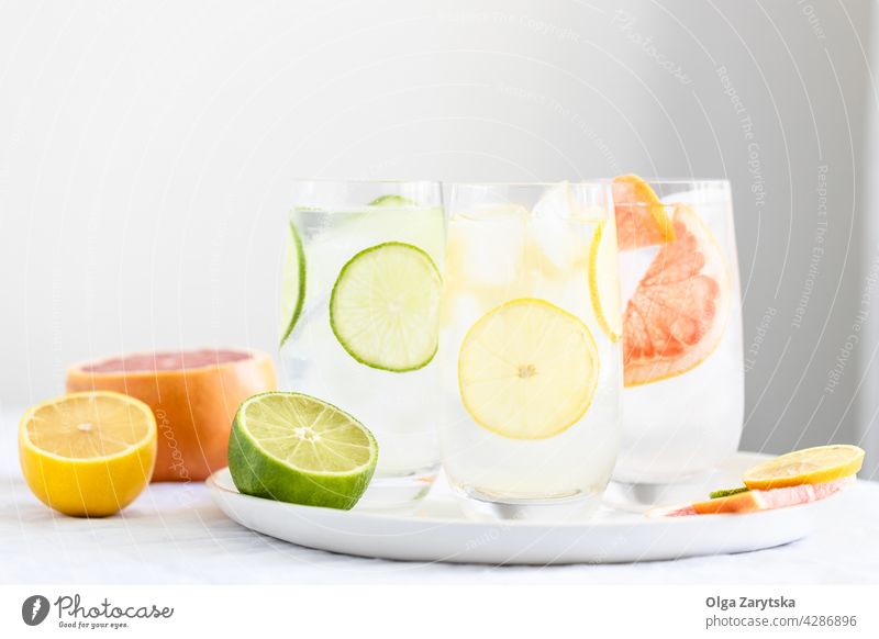 Drei Gläser mit kaltem Zitruswasser. trinken Limonade Wasser Eis Zitrone Grapefruit Kalk Sommer Glas Erfrischung Zitrusfrüchte Schweiß Kulisse Getränk drei