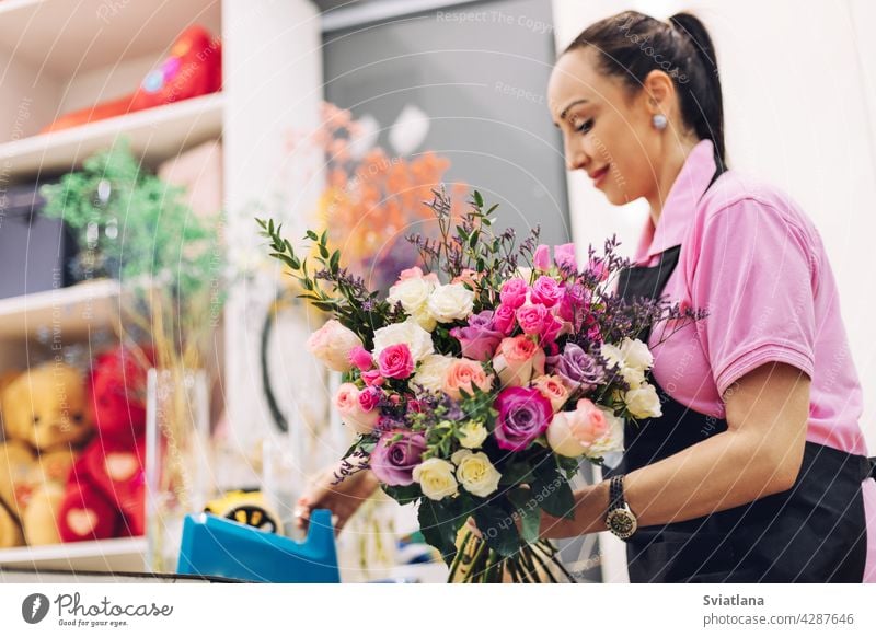 Ein Florist Mädchen in einem Blumenladen macht einen Blumenstrauß für den Urlaub. Familie Blumengeschäft, schöne Blume Anordnung. Werkstatt Blumenkomposition