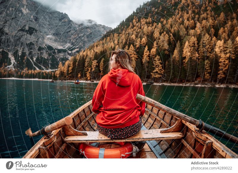 Anonyme Frau auf Boot im Dolomitensee Wald Gletscher Wasser Tourismus See Berge u. Gebirge Landschaft kalt schön reisen Natur grün Park Alpen blond Europa