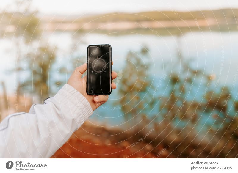 Anonyme Person, die eine Smartphone-App benutzt, um den Kompass zu betrachten Hand Technik & Technologie Anwendung Anschluss Weg Wald Reisender See Gerät Suche