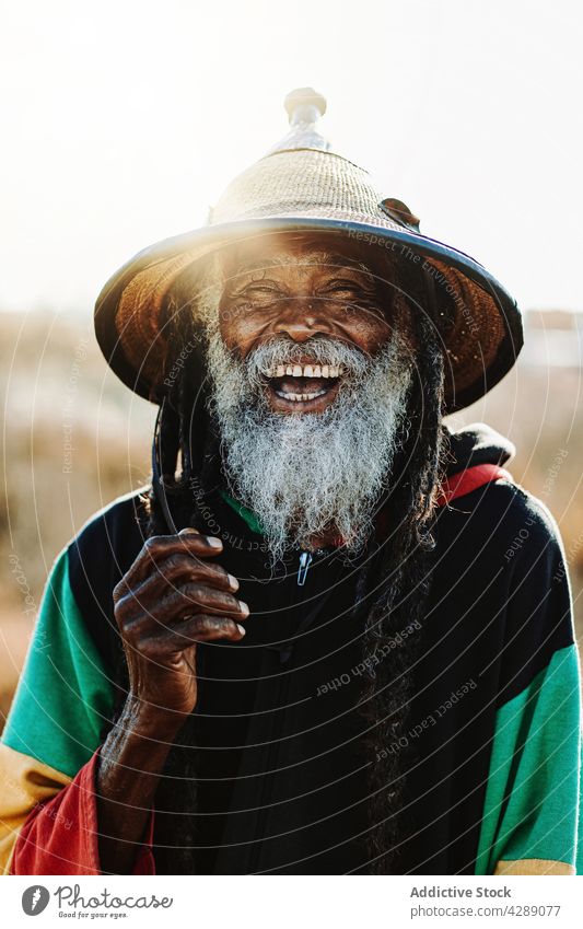 Gelassener Hippie-Rastamann auf dem Feld stehend Mann rastafarian Afrikanisch Glück Lächeln männlich Freude heiter Kultur ethnisch Reggae Karibik Natur