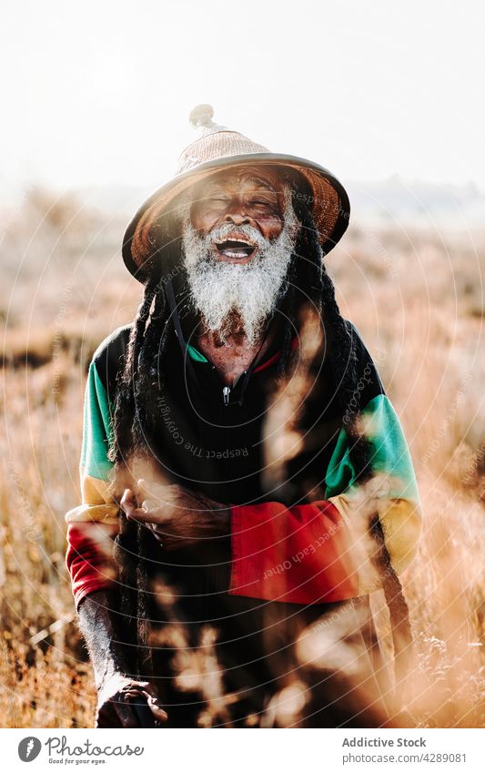Glücklicher Hippie-Rastamann auf dem Feld stehend Mann rastafarian Lächeln männlich Freude heiter Kultur ethnisch Reggae Karibik Natur Afroamerikaner heimatlich