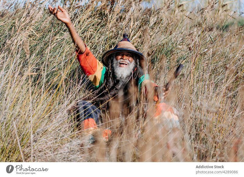 Glücklicher Hippie-Rastamann auf dem Feld stehend Mann rastafarian Lächeln männlich Freude heiter Kultur ethnisch Reggae Karibik Natur Afroamerikaner heimatlich