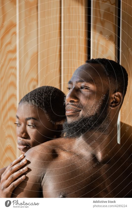 Romantisches schwarzes Paar lehnt an der Wand im Sonnenlicht romantisch Liebe Zusammensein sich[Akk] entspannen nackte Schultern ohne Hemd Partnerschaft
