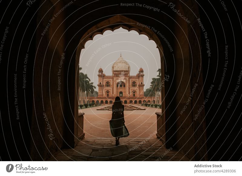 Frau im gewölbten Gang vor dem Safdarjung-Mausoleum stehend Silhouette bewundern Palast Grabmal Tourismus Ausflugsziel Sightseeing Wahrzeichen Erbe Fernweh