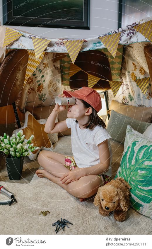 Mädchen spielt mit Karton Fernglas beim Camping zu Hause Glück beobachtend heimwärts Urlaub diy Spielzeug Zelt Sperrung Lächeln Coronavirus Schachtel