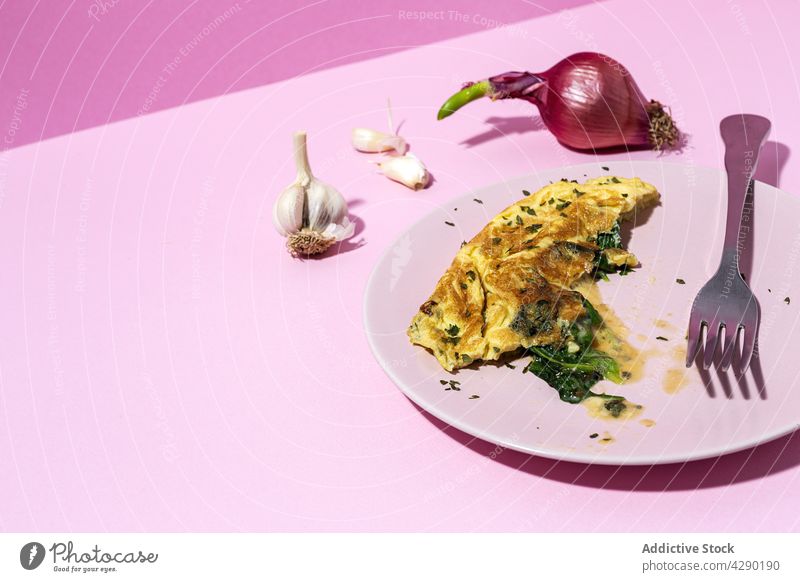 Leckeres Omelett mit frischem Blattspinat und gehackter Petersilie Spinat Frühstück Lebensmittel Ernährung natürlich Bestandteil lecker Besteck Gabel rot