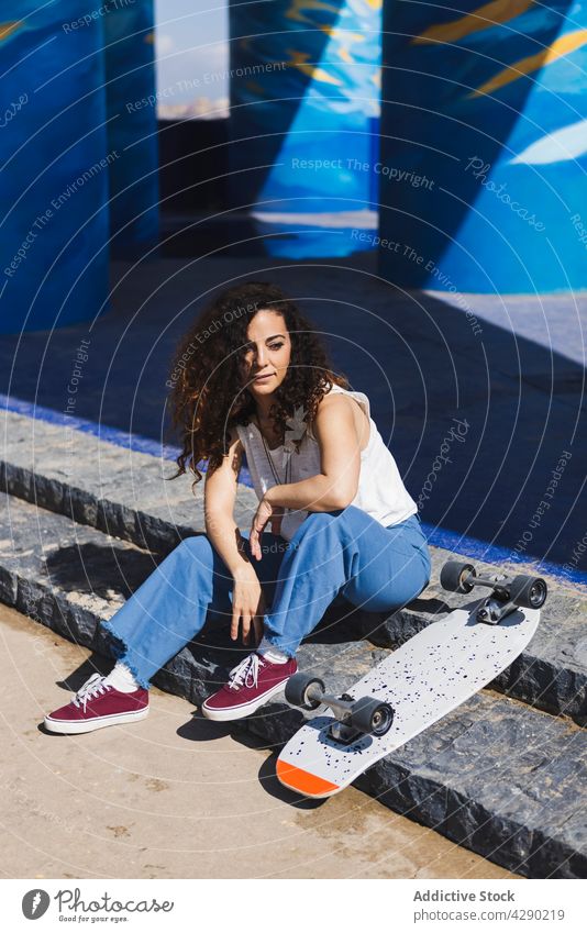 Nachdenkliche Frau sitzt mit Skateboard auf einer Treppe Hobby sportlich Straße Großstadt Streetstyle nachdenklich Skateboarderin Schritt urban Sport positiv