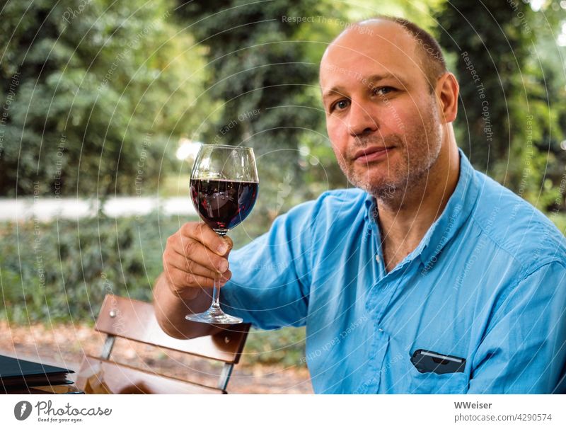 Ein Hoch auf das Leben, Wein, Weib und Gesang! Mann Essen Weinglas trinken zuprosten Prost Trinkspruch feierlich Rotwein Restaurant draußen Biergarten Heuriger