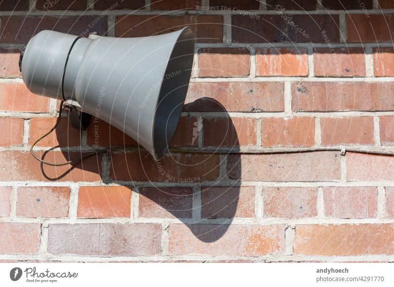 Megaphon vor einer alten Backsteinmauer Inserat Werbung Alarm wach ankündigen Ankündigung Aufmerksamkeit Hintergrund sich[Akk] hüten Backsteinwand