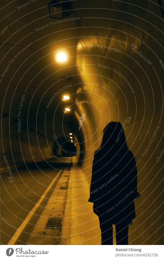 Das Mädchen ist zurück im Nachttunnel dunkel geheimnisvoll einsam Außenaufnahme Nachtaufnahme eine Person Straße Design Dunkelheit einzigartig Mann Gegensätze