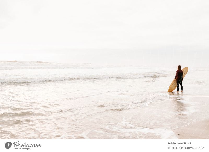 Anonymer Surfer am Strand mit Surfbrett Mann Natur stehen Sonnenuntergang winken im Freien Neoprenanzug Meeresküste männlich Brandung Sportler MEER Surfen Hobby
