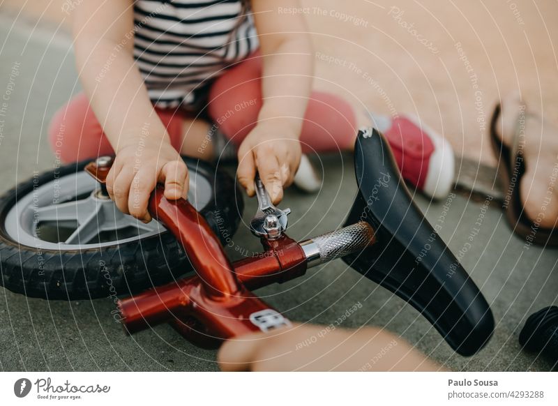 Kind repariert Fahrrad fixieren Fixierung Mensch authentisch reparierend Menschen Mechaniker Lifestyle Mädchen 1-3 Jahre Nahaufnahme unkenntlich Park lässig