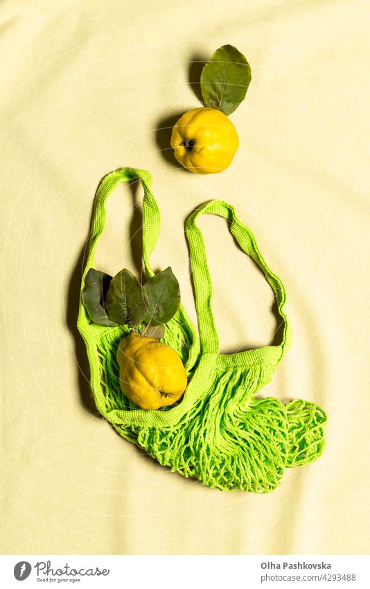 Zwei Quitte Apfel Früchte in grünem Netzbeutel auf Leinen gelb natürlich kaufen reif Tasche Blatt Vitamin Natur Ernährung organisch Vegetarier Quittenfrucht roh