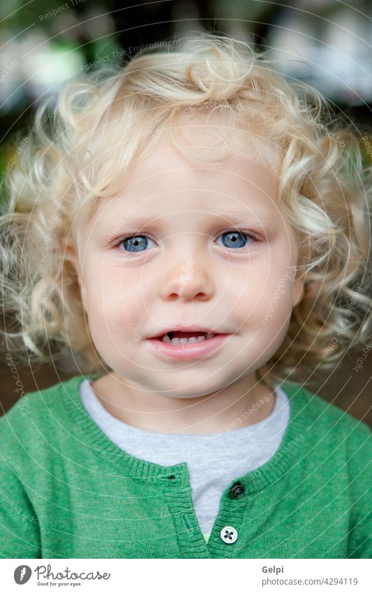 Kleiner Babyjunge mit lockigem Haar und blauen Augen Kind Kindheit Kleinkind gemütlich wenig weiß Junge im Freien klein Mode pulsierend Bekleidung schüchtern