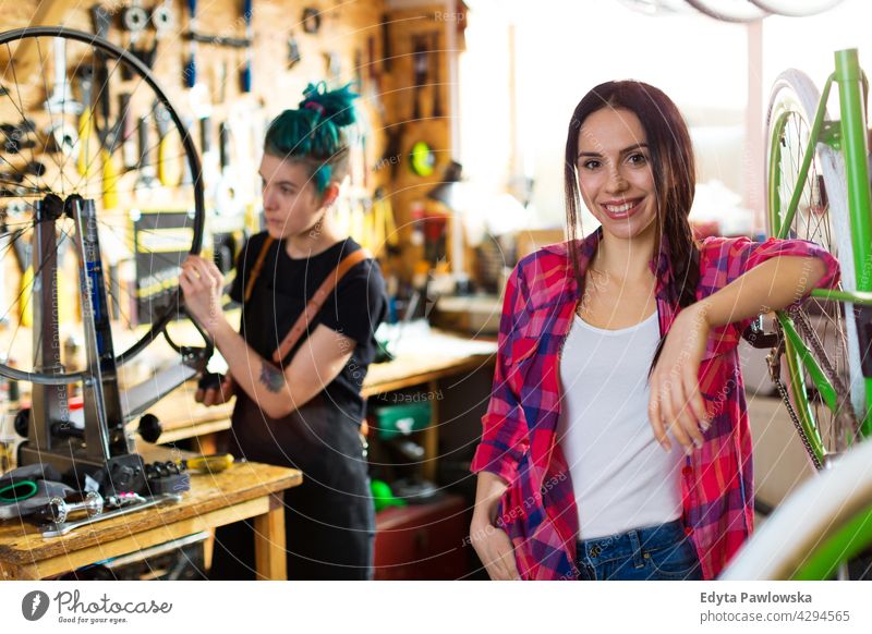 Zwei junge Frauen arbeiten in einer Fahrradwerkstatt Vertriebsmitarbeiter Fahrradmechaniker Radfahren Fahrradladen Business Einzelhandel Zyklus hilfreich