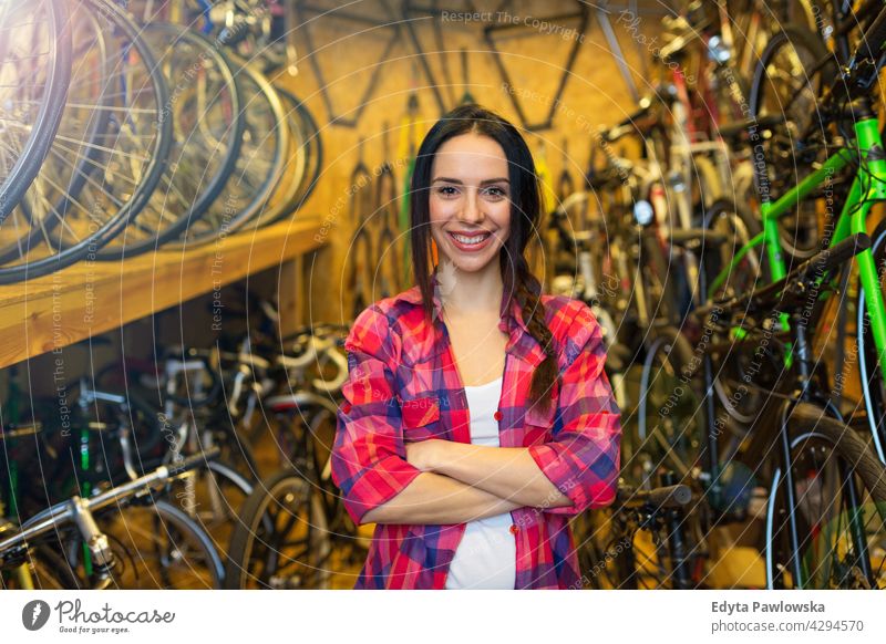 Junge Frau arbeitet in einer Fahrradwerkstatt Vertriebsmitarbeiter Fahrradmechaniker Radfahren Fahrradladen Business Einzelhandel Zyklus hilfreich