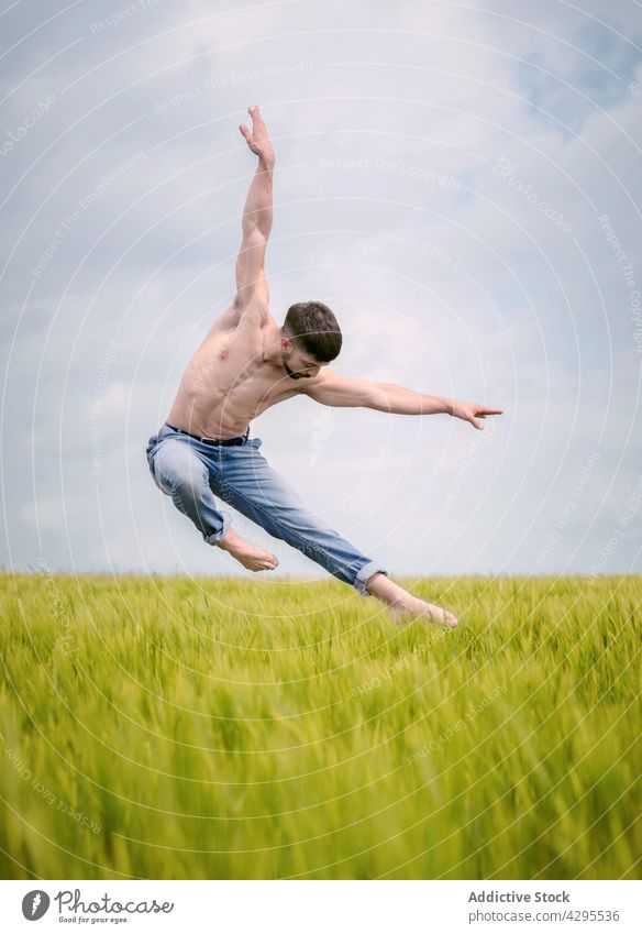 Anmutiger männlicher Balletttänzer, der in einem Feld auf dem Lande springt Mann springen Tanzen Natur Gras Freiheit sinnlich Landschaft ohne Hemd Energie