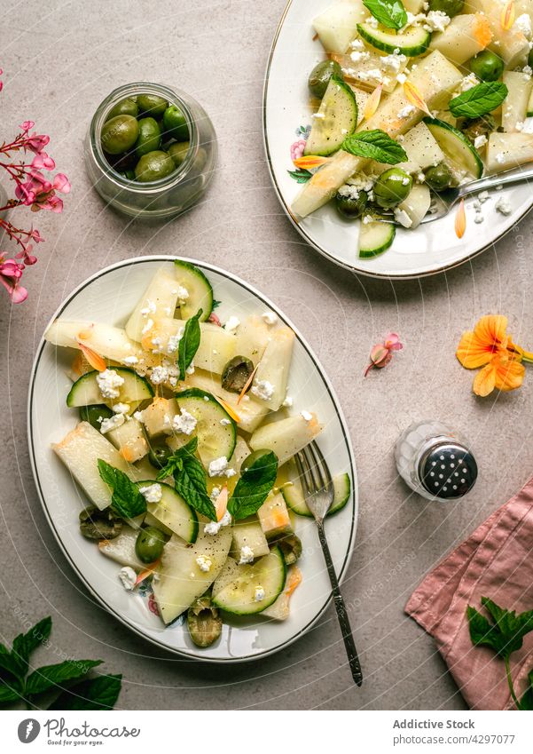 Melonensalat mit Essiggurken und Oliven Salatbeilage gesunde Ernährung Diät Veganer dienen Tisch Salatgurke oliv Kraut Serviette Salz Schüttler Teller organisch