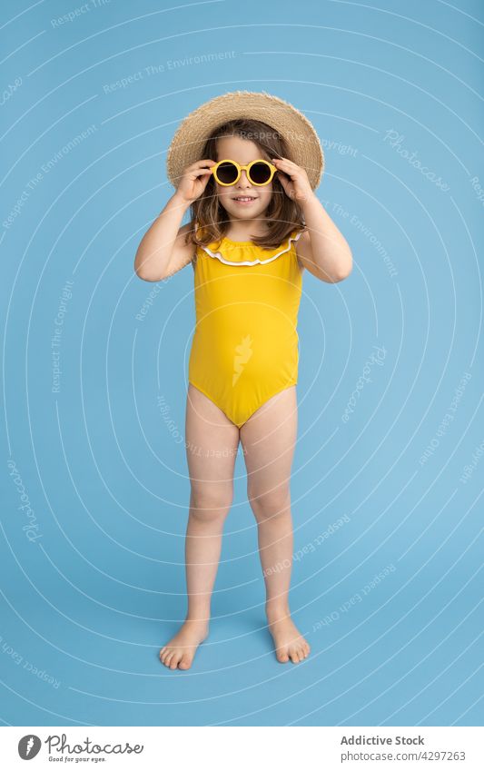 Stilvolles kleines Mädchen im Sommeroutfit gelb Mode Glück Lächeln Kind Sonnenbrille Strand niedlich wenig hell heiter trendy sorgenfrei Strohhut Farbe Outfit