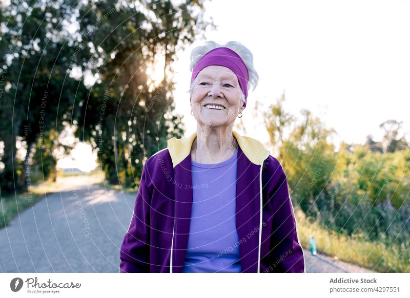 Positive ältere Sportlerin lächelnd und gehend Spaziergang Training Landschaft Fitness Morgen Gesundheit Sommer Straße Lächeln Frau Jogger gealtert Senior Glück