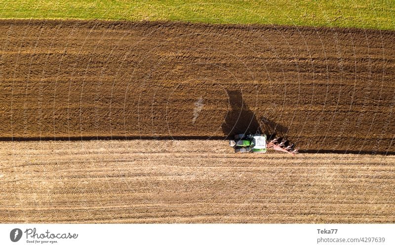 ein Traktor pflügt ein Feld von oben Landwirtschaft Bauernhof Landwirtschaft mit einem Traktor Feldfrüchte Pflügen eines Feldes Sonne moderne Landwirtschaft