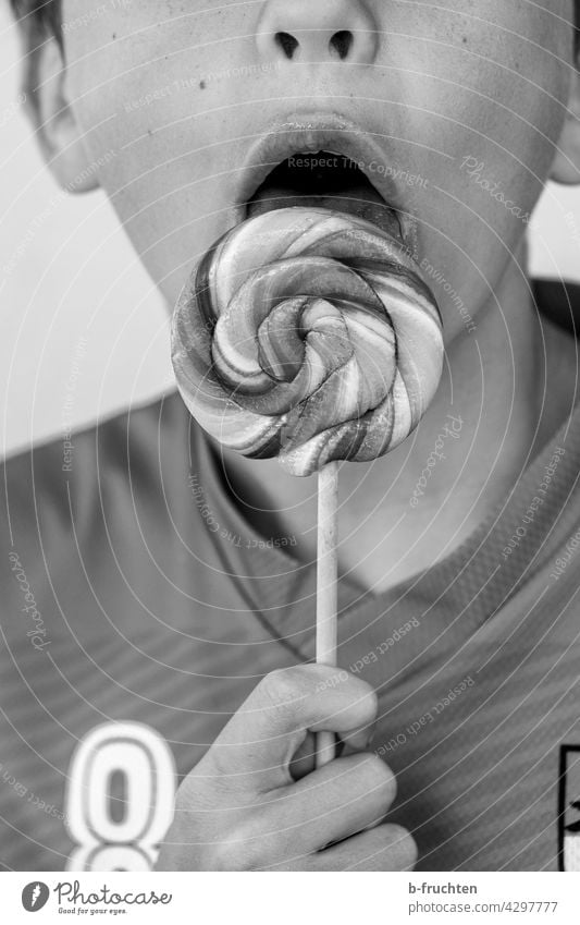 Kind mit Lollipop lutschen Lutscher lecker naschen Kindheit Schwarzweißfoto halten schlecken Junge Mund Zunge Zucker süß Süßwaren Ernährung Spirale ungesund